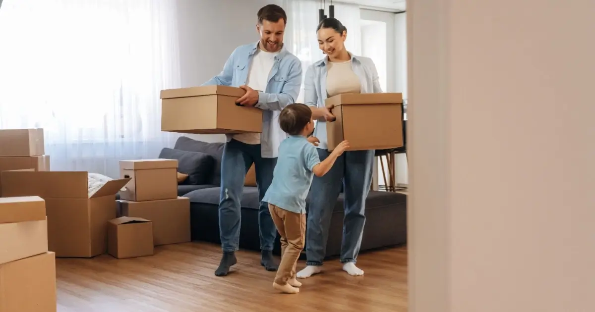 Familia joven descargando cajas mientras se muda a su nueva casa.