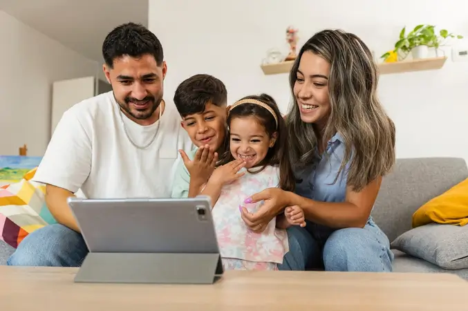 family on a sofa looking at a laptop