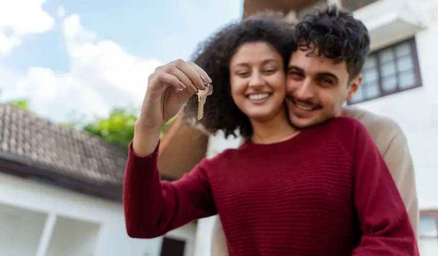 hispanic couple handed key to new house