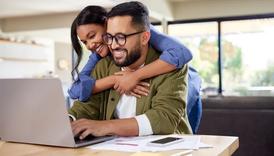 Pareja revisando opciones de hipoteca en línea desde su hogar.
